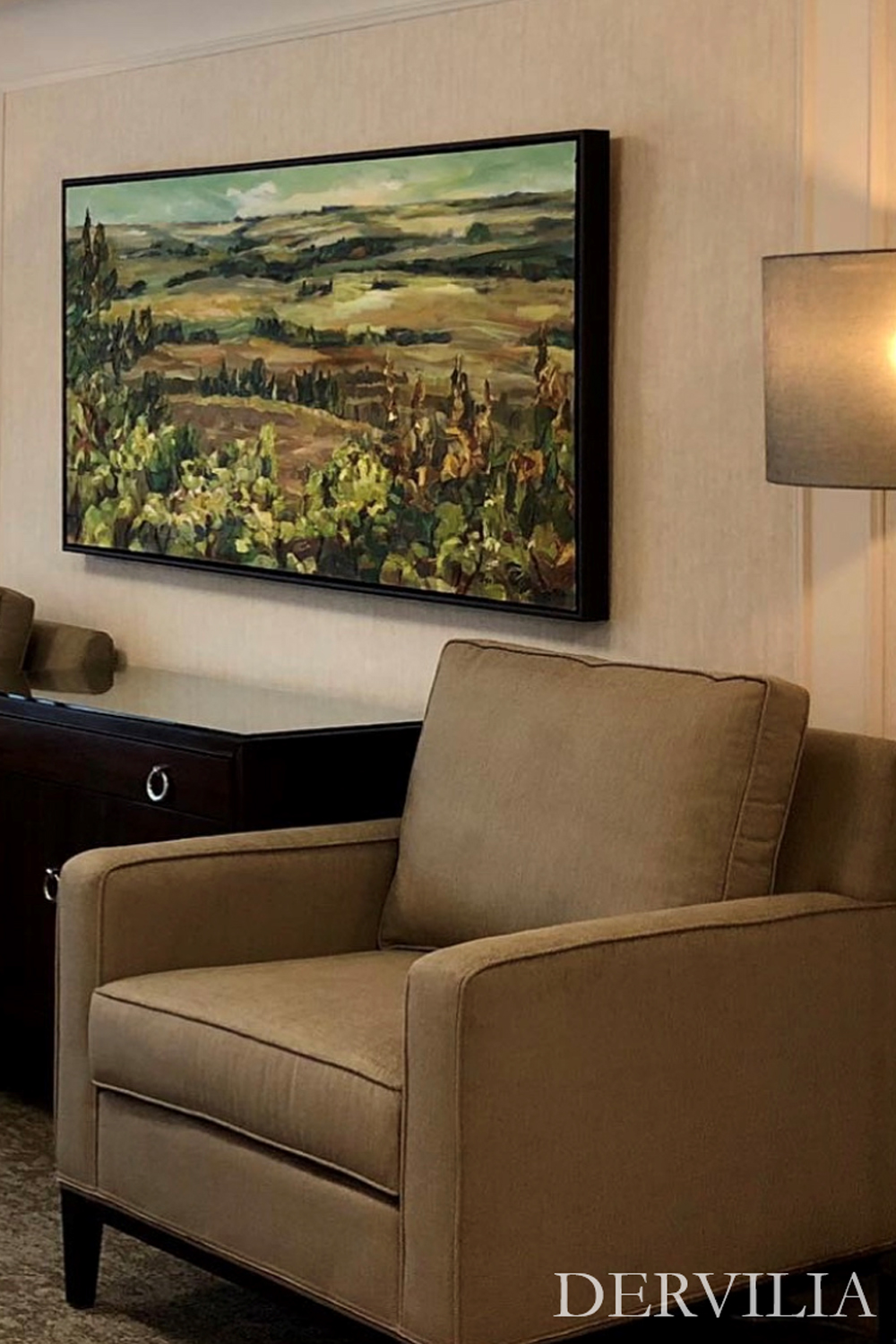 Comfortable seating area styled with upholstered armchairs, soft lighting, and a framed landscape painting as the focal point, reflecting Dervilia’s art-driven approach to creating calm, welcoming interior spaces.