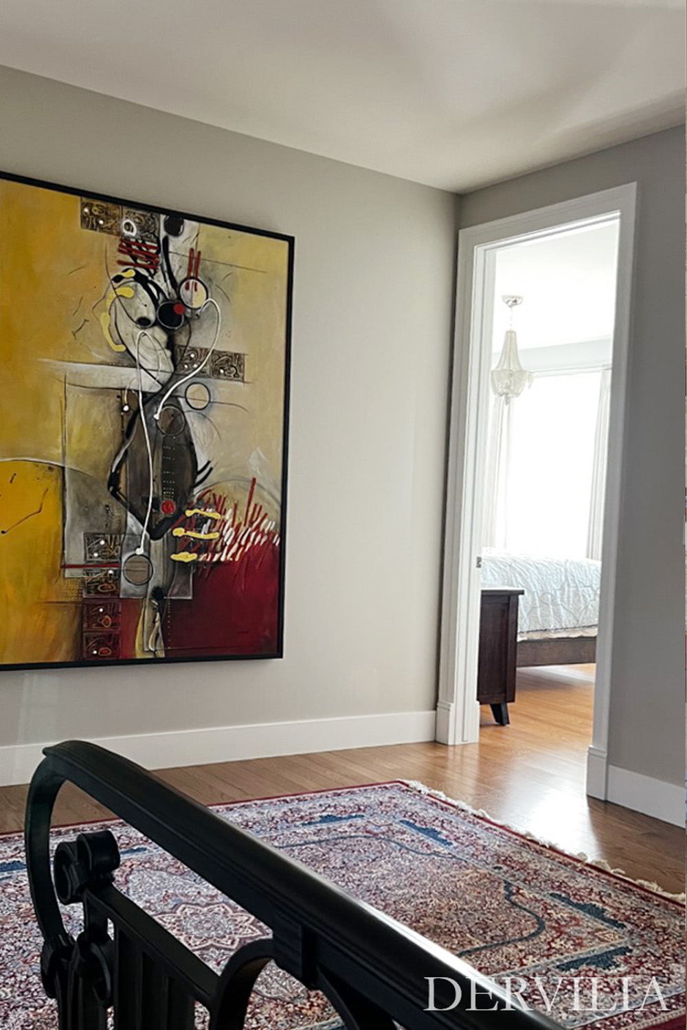 Large abstract painting displayed along a hallway overlooking a stair landing, with warm wood floors and natural light, illustrating Dervilia’s art-led approach to visual flow and spatial connection within the home.