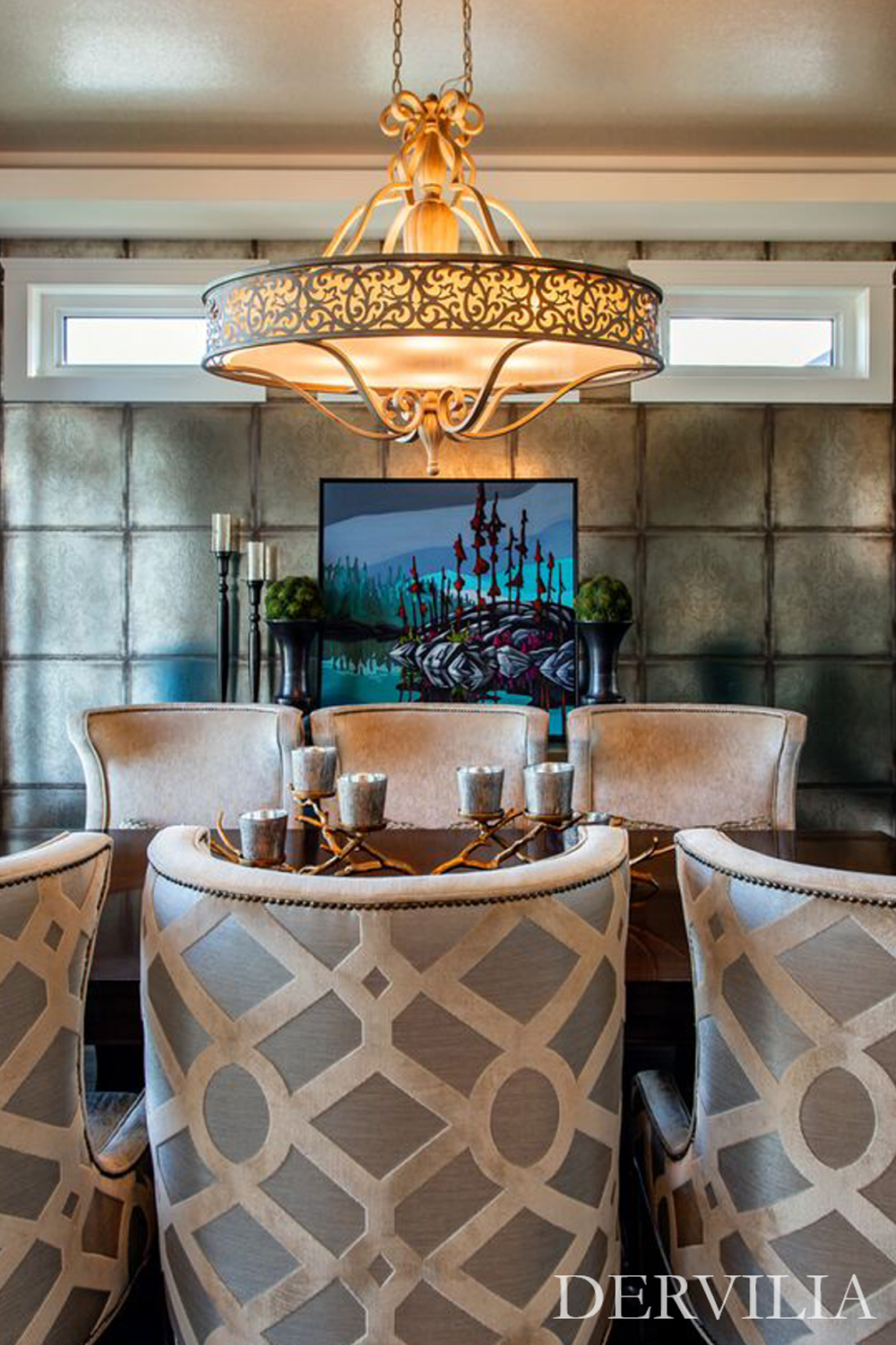 Elegant dining setting featuring sculptural upholstered chairs, an ornate chandelier, textured wall panels, and a framed artwork as the focal point, expressing Dervilia’s art-led approach to refined, symmetrical interior design.