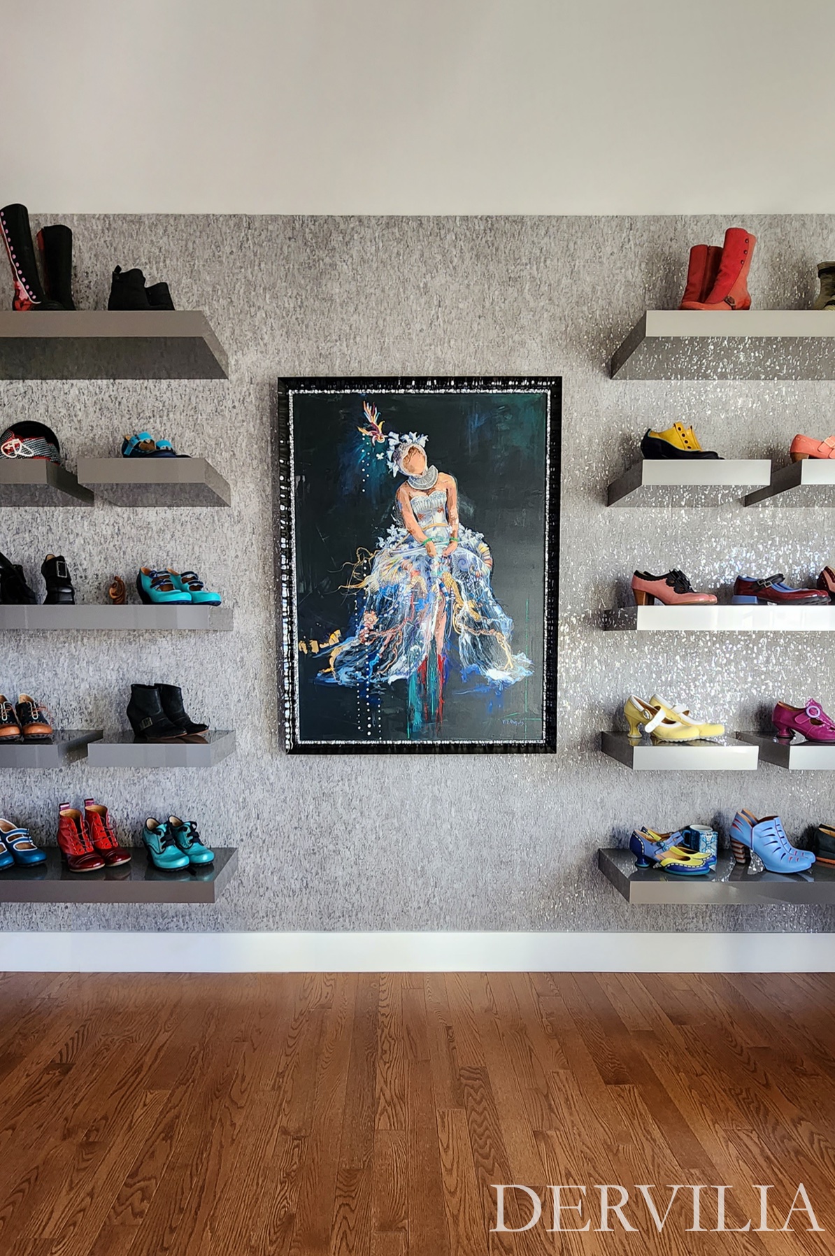 Statement figurative artwork centered within a symmetrical wall of floating shelves displaying curated footwear and objects, showcasing Dervilia’s art-led approach to composition, balance, and expressive interior design.
