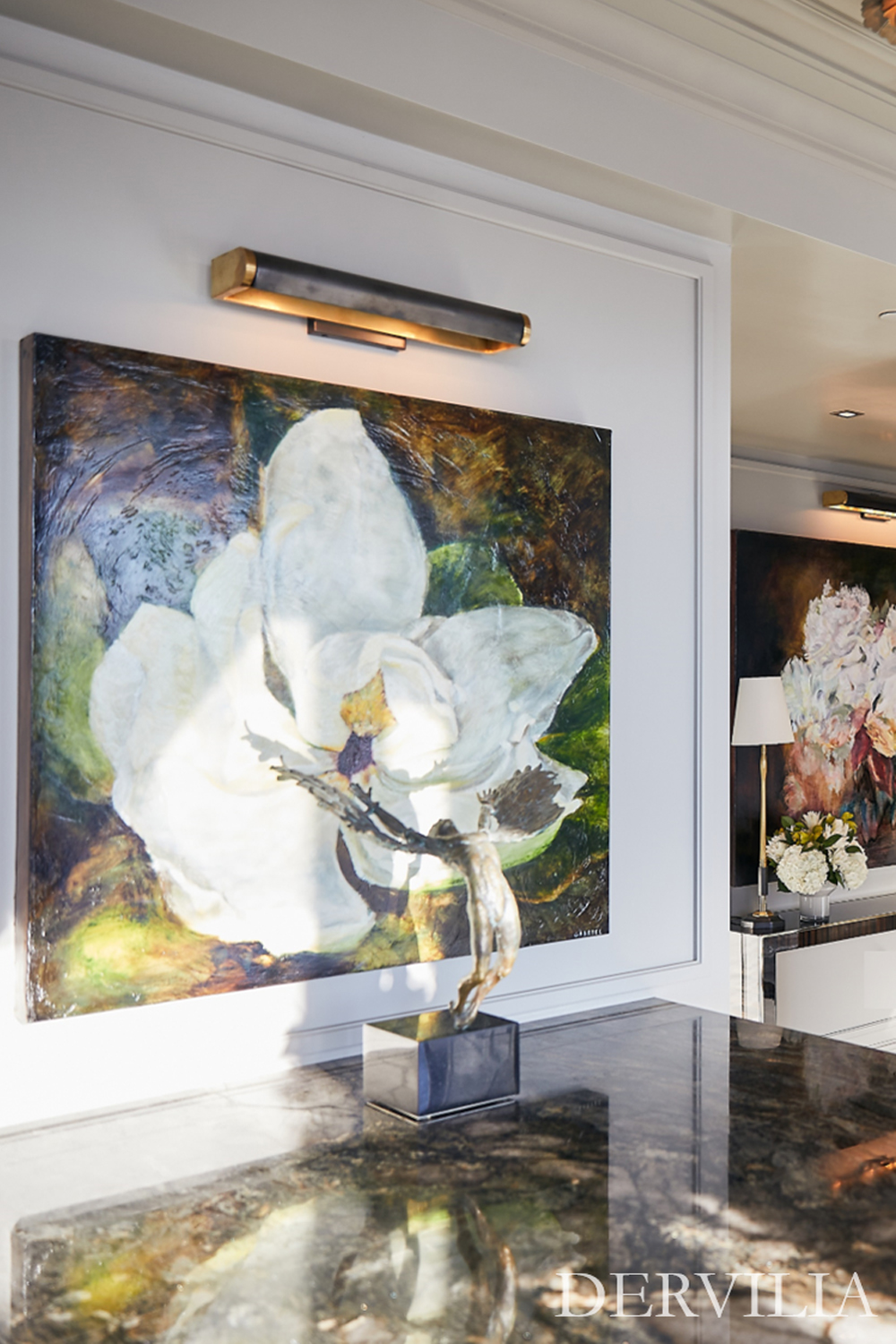 Luxury kitchen interior featuring a large-scale floral artwork integrated into custom white cabinetry, dark marble countertops, brass lighting accents, and detailed ceiling moldings, showcasing Dervilia’s art-led interior design approach.